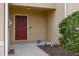 Inviting front porch with a red front door, landscaping and an ADT security sign at 209 Arbor Lakes Dr, Davenport, FL 33896