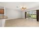 Bright living room featuring tile flooring, ceiling fan, and sliding glass doors to a screened-in lanai at 209 Arbor Lakes Dr, Davenport, FL 33896