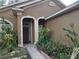 Close up of the entrance to a beautiful home with a tiled walkway and manicured plants at 2119 Kaylas Ct, Orlando, FL 32817