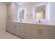 Modern bathroom with double sinks, illuminated mirrors, and custom cabinetry at 2721 Ingeborg Ct, Windermere, FL 34786