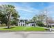 Wide exterior of home featuring a manicured lawn, mature trees, and a paved driveway at 2721 Ingeborg Ct, Windermere, FL 34786