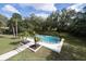 Aerial view of a private backyard swimming pool with a black safety fence and surrounding lush landscaping at 2721 Ingeborg Ct, Windermere, FL 34786