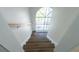 Bright staircase featuring wood steps, a stylish handrail, and a large arched window letting in natural light at 2721 Ingeborg Ct, Windermere, FL 34786