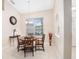 Light-filled dining room featuring a round table, decorative clock, neutral paint, and ceramic tile flooring at 3203 Victoria Ln, Eustis, FL 32726