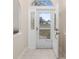 Light filled foyer featuring neutral tile flooring and a decorative glass front door that is open to the outside at 3203 Victoria Ln, Eustis, FL 32726