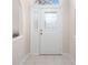 Bright foyer features neutral tile flooring, an arched transom window, and a front door with decorative glass at 3203 Victoria Ln, Eustis, FL 32726