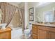 Cozy bathroom featuring decorative shower curtain, framed art, granite vanity, and neutral tile flooring at 3289 Saloman Ln, Clermont, FL 34711