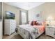 Charming bedroom featuring a white bed frame, modern dresser and bedside table, and bright, natural lighting at 3289 Saloman Ln, Clermont, FL 34711