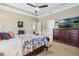 Bright bedroom with a patterned bed, large dresser, tray ceiling, and natural light, a calm and inviting space at 3289 Saloman Ln, Clermont, FL 34711