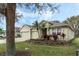 Landscaped home with a spacious three-car garage, vibrant flowerbeds, and brick driveway at 3289 Saloman Ln, Clermont, FL 34711