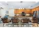 Charming kitchen featuring wood cabinetry, granite countertops, tiled backsplash, and seating at the breakfast bar at 3289 Saloman Ln, Clermont, FL 34711