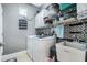 Functional laundry room featuring washer, dryer, sink, storage cabinets, and decorative tile backsplash at 3289 Saloman Ln, Clermont, FL 34711