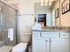 Bathroom featuring a granite vanity, a framed mirror, and a glass-enclosed tiled shower at 3401 Lilac Way, Davenport, FL 33897