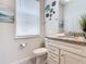 Well-lit bathroom with decorative wall art, a large window, white vanity, and granite countertop at 3401 Lilac Way, Davenport, FL 33897