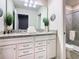 Bright bathroom featuring a double vanity, granite countertops, and a glass-enclosed shower at 3401 Lilac Way, Davenport, FL 33897