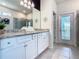 Bright bathroom featuring granite countertops, white cabinets, and a large mirror, creating a luxurious space at 3401 Lilac Way, Davenport, FL 33897