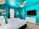 Bright bedroom with turquoise walls, white furniture, modern ceiling fan, and sophisticated decor at 3401 Lilac Way, Davenport, FL 33897