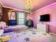 Whimsical bedroom with two twin beds, purple walls, and colorful cartoon murals at 3401 Lilac Way, Davenport, FL 33897