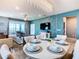 Open-concept living space with blue accent wall, decorative chandelier, and dining area with seating for six at 3401 Lilac Way, Davenport, FL 33897