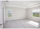 Light-filled bedroom with neutral carpet and tray ceiling at 4898 Lyric Dr, Mascotte, FL 34753