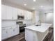 Modern kitchen featuring an island, stainless steel appliances, and white cabinetry at 4898 Lyric Dr, Mascotte, FL 34753