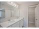 Bathroom featuring double sinks, quartz countertops and a large mirror at 4906 Lyric Dr, Mascotte, FL 34753