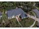 Aerial view of a beige home with a gray roof, surrounded by trees and greenery at 4978 Fawn Ridge Pl, Sanford, FL 32771