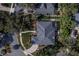 Overhead view of a home with a large roof, manicured lawn, pool, and screened-in porch, surrounded by lush greenery at 4978 Fawn Ridge Pl, Sanford, FL 32771