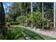 Beautiful backyard landscaping featuring palms, lush tropical plants, and stone pavers and benches at 4978 Fawn Ridge Pl, Sanford, FL 32771