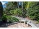 Lush landscaping surrounds this peaceful backyard retreat with pavers, stone benches and lush tropical views at 4978 Fawn Ridge Pl, Sanford, FL 32771