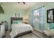 Bright bedroom with a full size bed, grey wood floors and natural light from the large window at 4978 Fawn Ridge Pl, Sanford, FL 32771