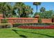 Landscaped community entrance with brick signage and colorful flowerbeds at 4978 Fawn Ridge Pl, Sanford, FL 32771