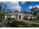 Charming one-story beige home with blue shutters, a brick walkway, and lush green landscaping at 4978 Fawn Ridge Pl, Sanford, FL 32771