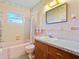 The pink bathroom features a tub with a shower and a vanity at 522 Wisconsin Ave, St Cloud, FL 34769