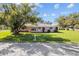 Charming single-story home with a lush green lawn, inviting curb appeal, and mature shade trees at 522 Wisconsin Ave, St Cloud, FL 34769