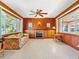 Inviting Gathering room featuring wood paneling, a cozy fireplace, and an abundance of natural light at 522 Wisconsin Ave, St Cloud, FL 34769