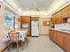 A vintage kitchen featuring wood cabinets, a white refrigerator, and a small kitchen table at 522 Wisconsin Ave, St Cloud, FL 34769