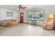 Bright living room with a ceiling fan, neutral-toned walls, and a large front window at 522 Wisconsin Ave, St Cloud, FL 34769