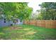 Backyard features a new wooden fence, mature tree, and small amount of grass at 5433 Vanderlin St, Orlando, FL 32810