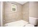 Bathroom features a tub with tiled wall and neutral-colored walls at 5433 Vanderlin St, Orlando, FL 32810