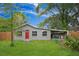 Charming single-story home featuring a vibrant red door, well-maintained lawn and a convenient carport at 5433 Vanderlin St, Orlando, FL 32810