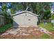 Exterior of the shed on a concrete slab with some dead leaves and a blue tarp in the background at 5433 Vanderlin St, Orlando, FL 32810