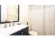 Bathroom with a dark vanity and shower with a patterned curtain at 549 Hunter Cir, Kissimmee, FL 34758