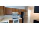 Kitchen featuring stainless steel refrigerator, white stove and hood, and wood cabinets at 5843 Willow Leaf Ct, Orlando, FL 32807