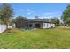 Backyard featuring a screened-in pool, grassy yard, and view of the home's exterior at 6229 Indian Meadow St, Orlando, FL 32819