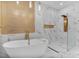 Modern bathroom with marble floors, a gold accent wall, a bathtub and glass shower at 6229 Indian Meadow St, Orlando, FL 32819