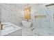 Modern bathroom featuring marble floors, a gold-accented wall, a bathtub, and glass shower at 6229 Indian Meadow St, Orlando, FL 32819