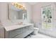 Bathroom showcasing marble-style walls, gray vanity with gold accents, a mirror, and a toilet at 6229 Indian Meadow St, Orlando, FL 32819