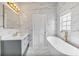 Modern bathroom featuring marble-like tile, soaking tub, vanity, and updated fixtures at 6229 Indian Meadow St, Orlando, FL 32819