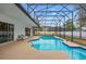 Screened-in pool with blue tiling, surrounded by concrete and white rock landscaping at 6229 Indian Meadow St, Orlando, FL 32819